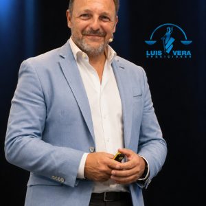 Luis Vera, director y preparador de Justicia, de pie con micrófono durante una conferencia