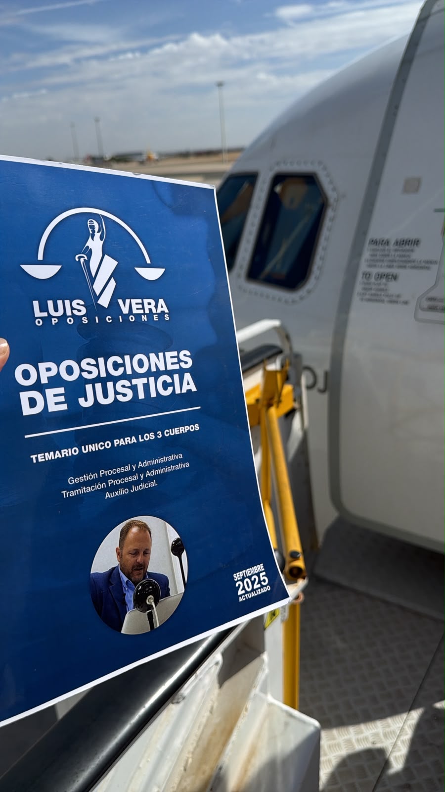 Temario de Luis Vera Oposiciones junto a la puerta de un avión antes del viaje de un alumno al examen de Justicia.